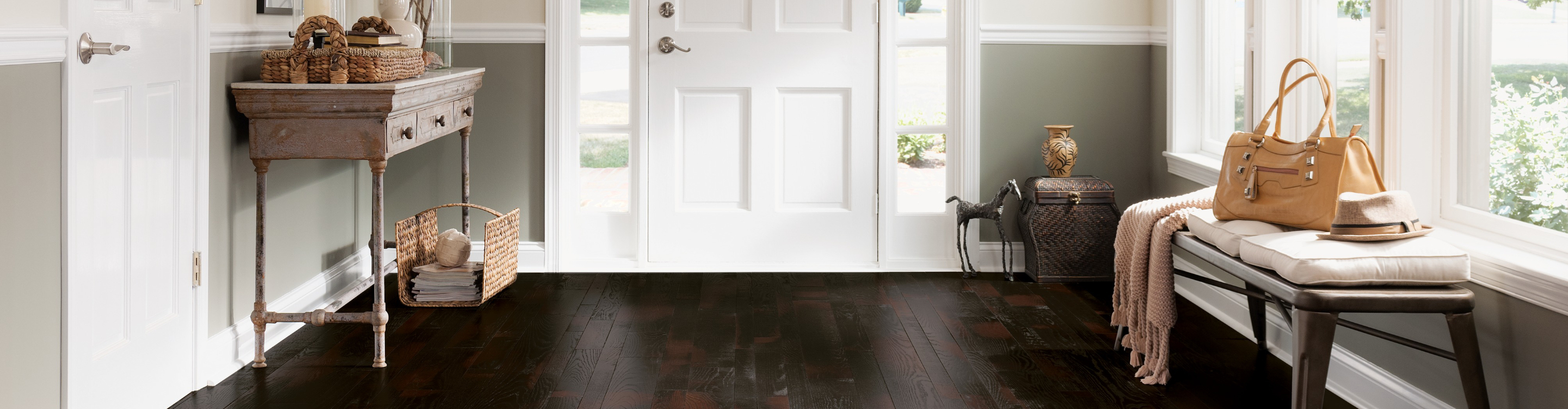 dark burgundy oak hardwood floors in entry way with pendant lighting and white door